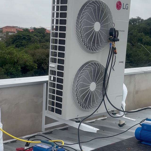 Condensadora LG de dois ventiladores na laje, ligada ao manifold e à bomba de vácuo