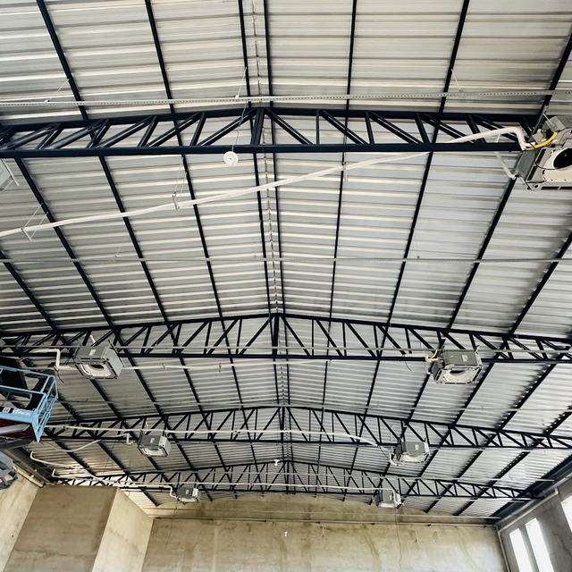 Aparelhos cassete instalados na estrutura metálica de um galpão, com plataforma elevatória